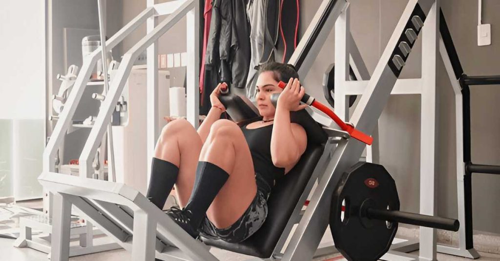A woman performing hack squat