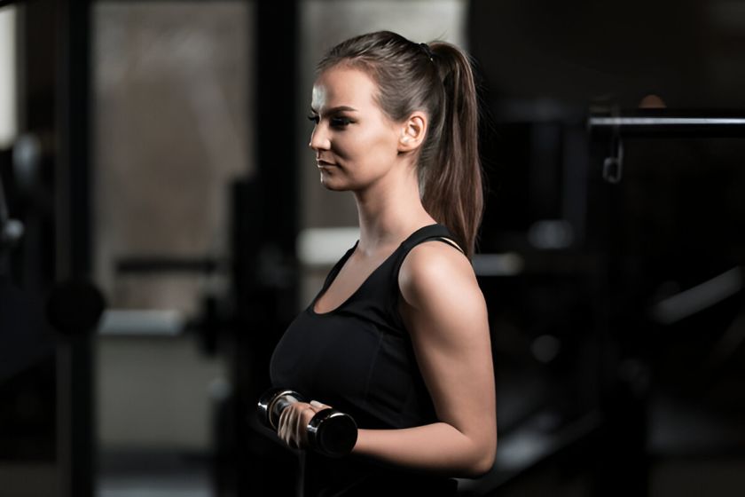 A woman performing Dumbbell Curls.