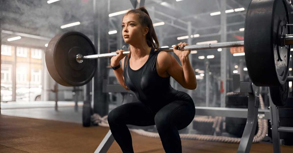 A woman performing back squat